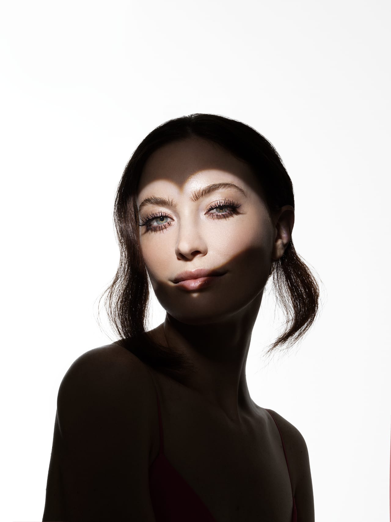 Ritratto ad alto contrasto su fondo bianco, trucco scultoreo.