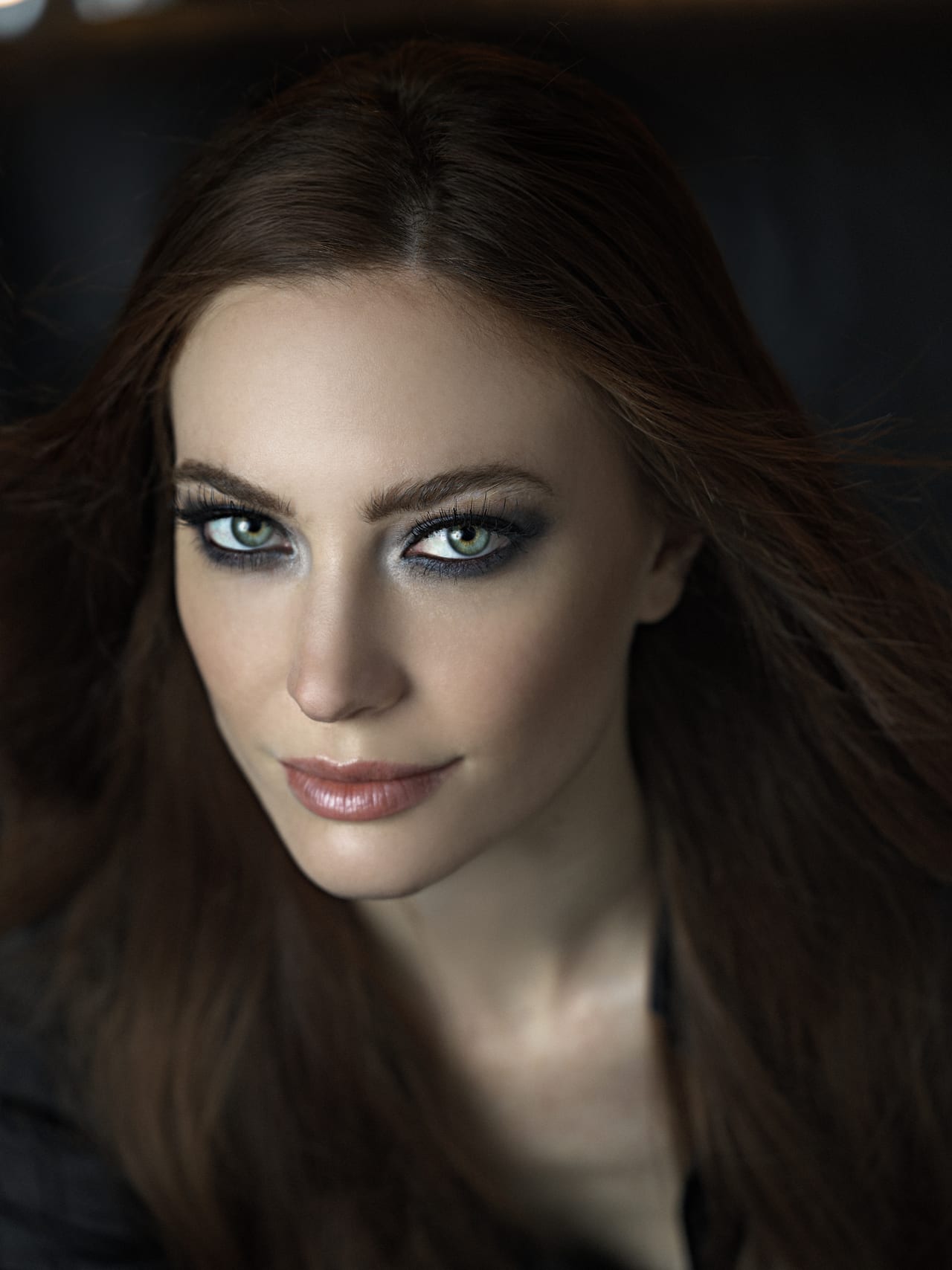 Ritratto ravvicinato con smoky eye intenso e incarnato luminoso.