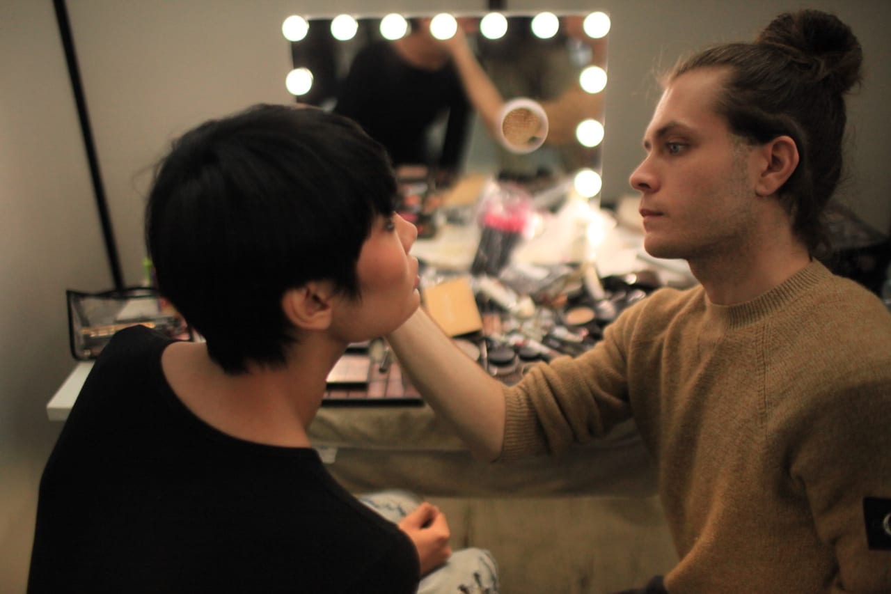 Sessione di trucco a più mani su una modella durante l’esercitazione.