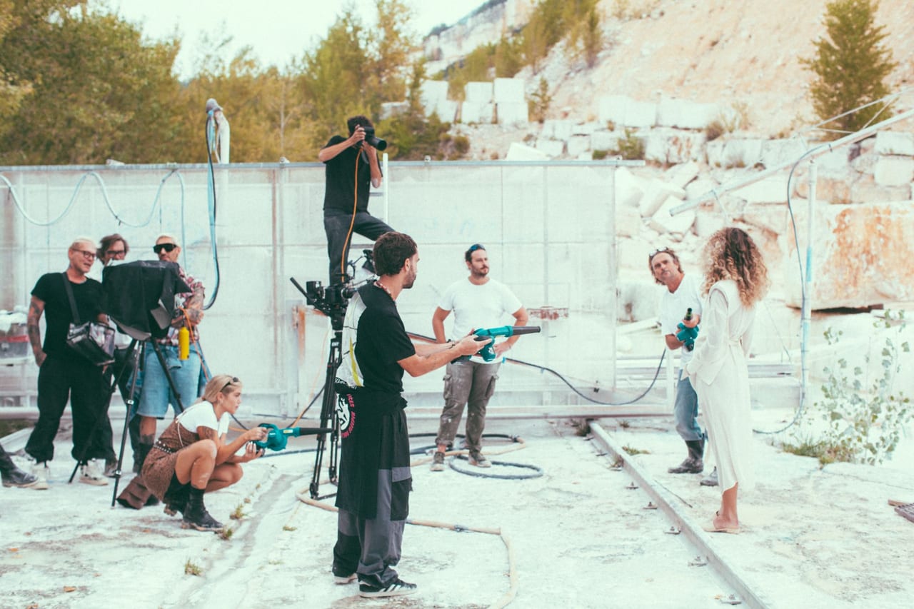 Troupe al lavoro su un set fotografico allestito in una cava di marmo.