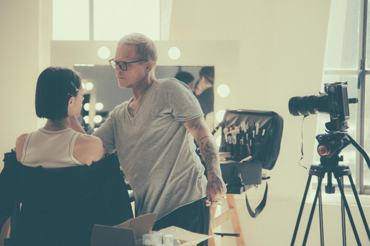 Docente e modella alla postazione trucco dello studio, davanti alla macchina fotografica.